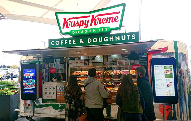Customers ordering themselves at the trailer kiosks — the queue-buster at a busy pitch.
